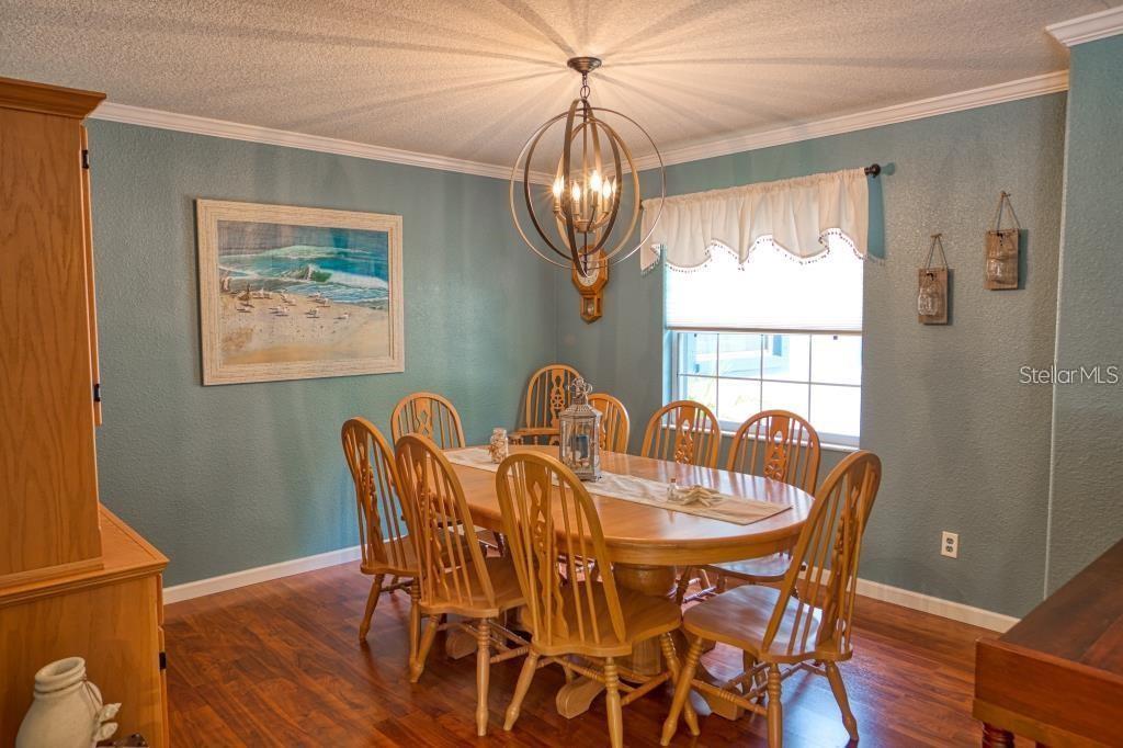 12802 North 53rd Street Temple Terrace, FL 33617 - Photo 10 of 38 a view of a dining room with furniture wooden floor and a chandelier