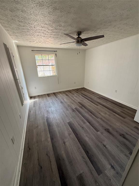 4320 Lake Underhill Road, Unit 14D2 Orlando, FL 32803 - Photo 3 of 15 en empty room with wooden floor fan and windows