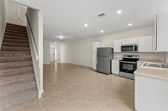 a view of kitchen and wooden floor in an empty room