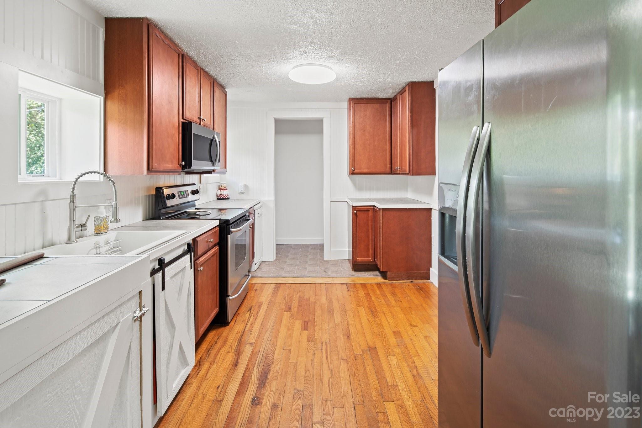 115 James E Davis Drive Mills River, NC 28759 - Photo 17 of 27 a kitchen with kitchen island granite countertop a sink appliances cabinets and counter space