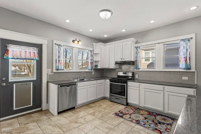a kitchen with stainless steel appliances granite countertop a stove sink and cabinets