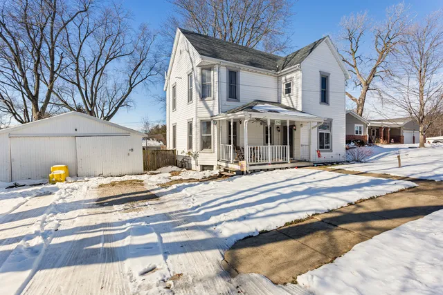 a view of a house with snow on the side of the road