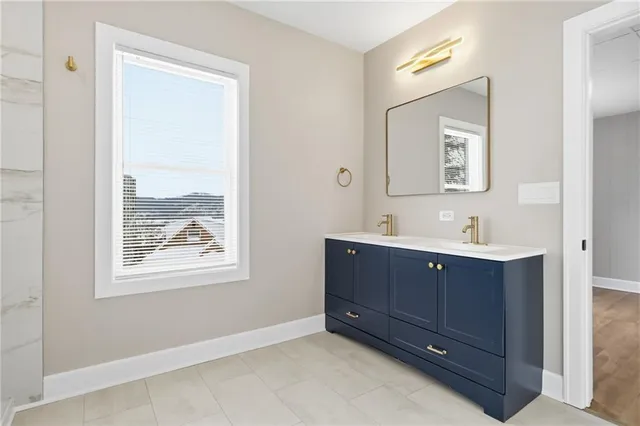a bathroom with a double vanity sink and mirror with window