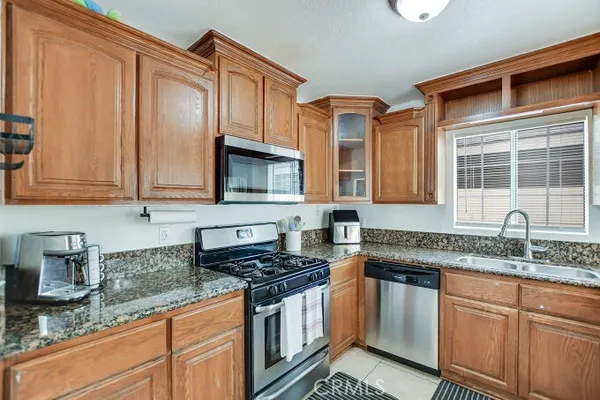 a kitchen with granite countertop stainless steel appliances a sink stove and cabinets