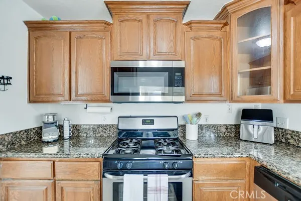 a kitchen with granite countertop a stove sink and cabinets