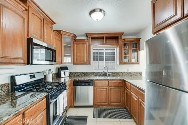 a kitchen with stainless steel appliances granite countertop a stove a sink dishwasher and a refrigerator