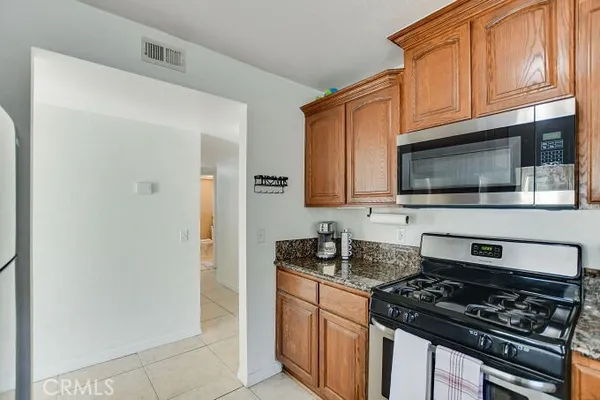 a kitchen with stainless steel appliances granite countertop a stove and a microwave