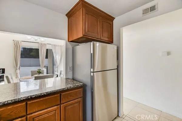a kitchen with stainless steel appliances granite countertop a refrigerator a sink and cabinets
