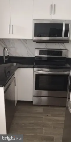 a kitchen with a refrigerator and a stove top oven