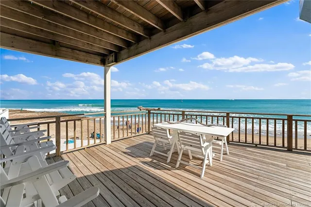 a view of a balcony with wooden floor and outdoor seating