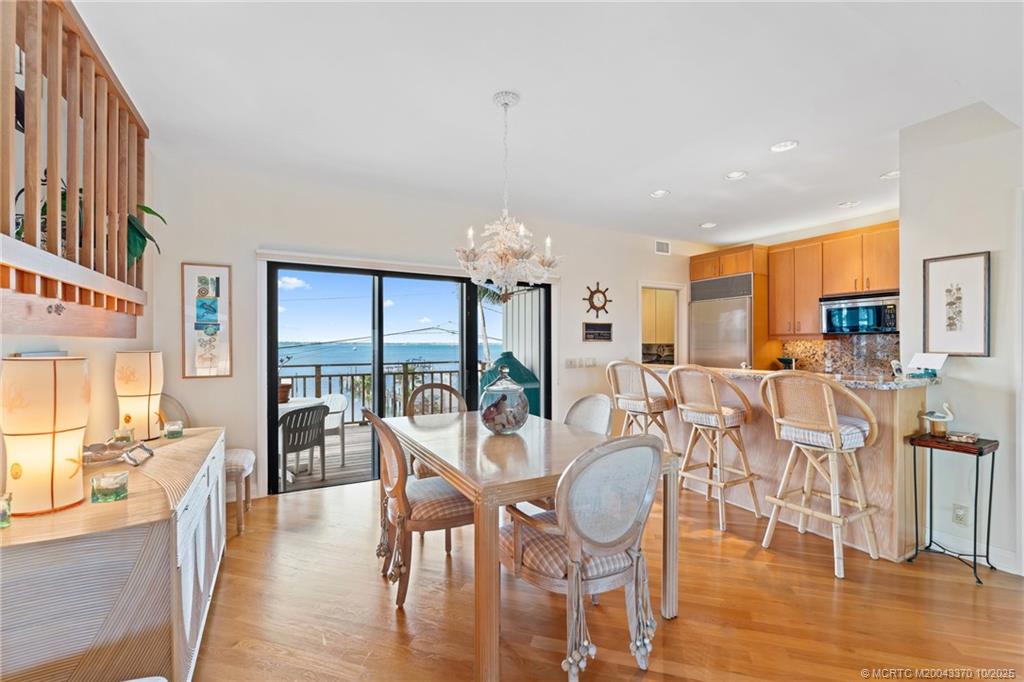 777 Southeast MacArthur Boulevard Stuart, FL 34996 - Photo 14 of 46 a dining room with furniture a chandelier and wooden floor