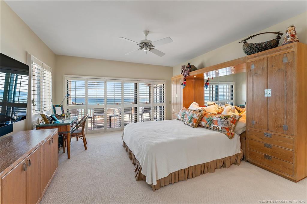 777 Southeast MacArthur Boulevard Stuart, FL 34996 - Photo 23 of 46 a bedroom with a bed couch and a large window