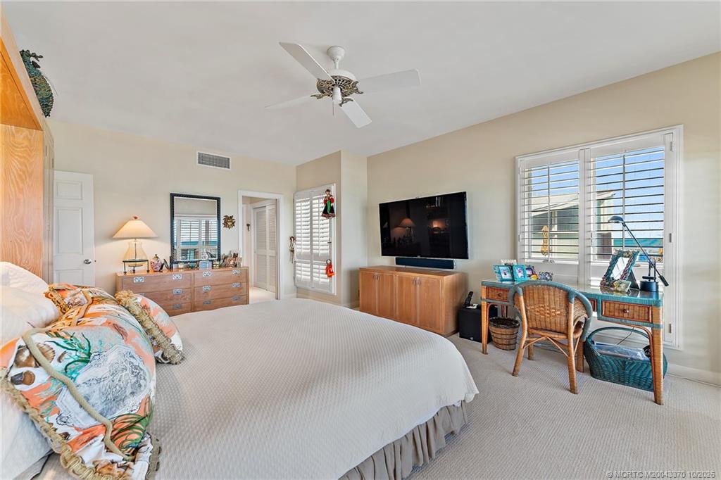 777 Southeast MacArthur Boulevard Stuart, FL 34996 - Photo 24 of 46 a bedroom with a bed and a flat screen tv