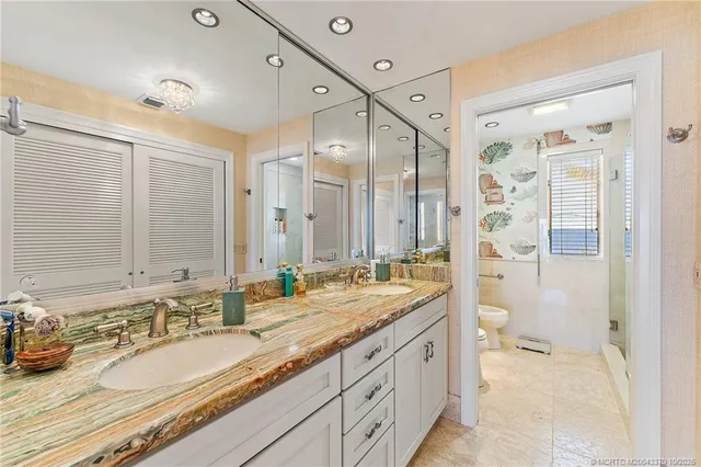 a bathroom with a granite countertop double vanity sink mirror double and shower
