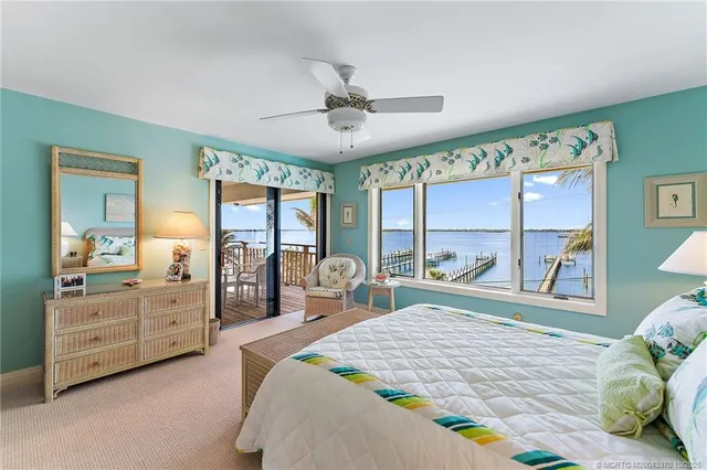 a bedroom with a bed and large windows