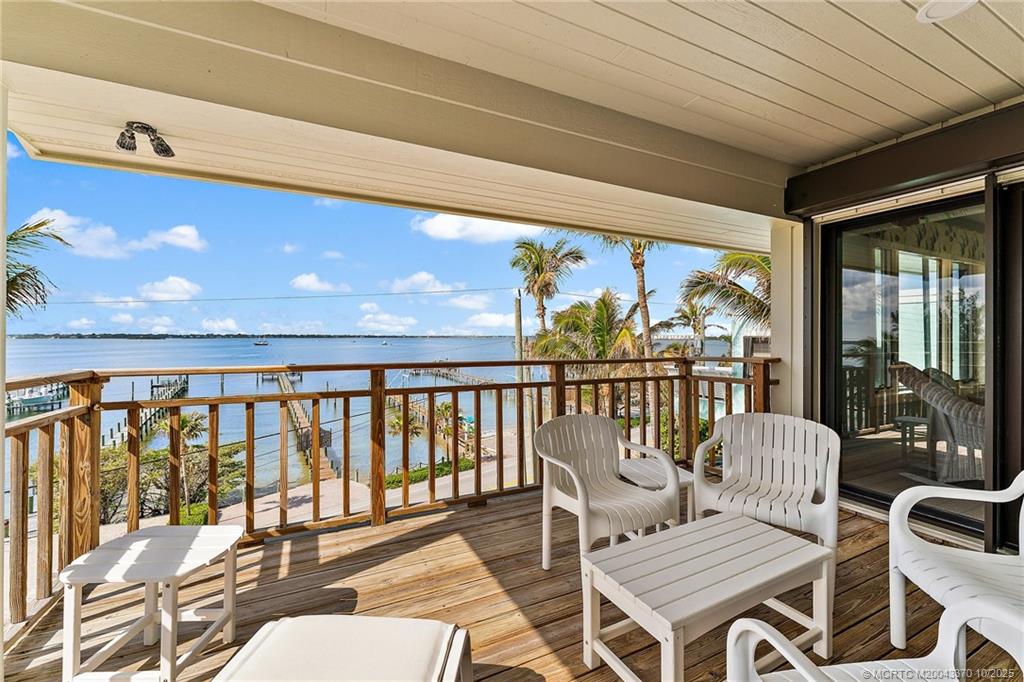777 Southeast MacArthur Boulevard Stuart, FL 34996 - Photo 29 of 46 a balcony with couple of chairs and wooden floor