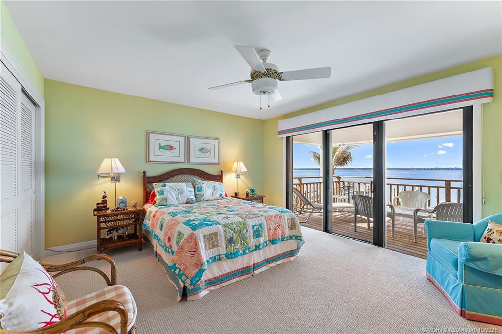 777 Southeast MacArthur Boulevard Stuart, FL 34996 - Photo 31 of 46 a bedroom with a bed couch and a large window