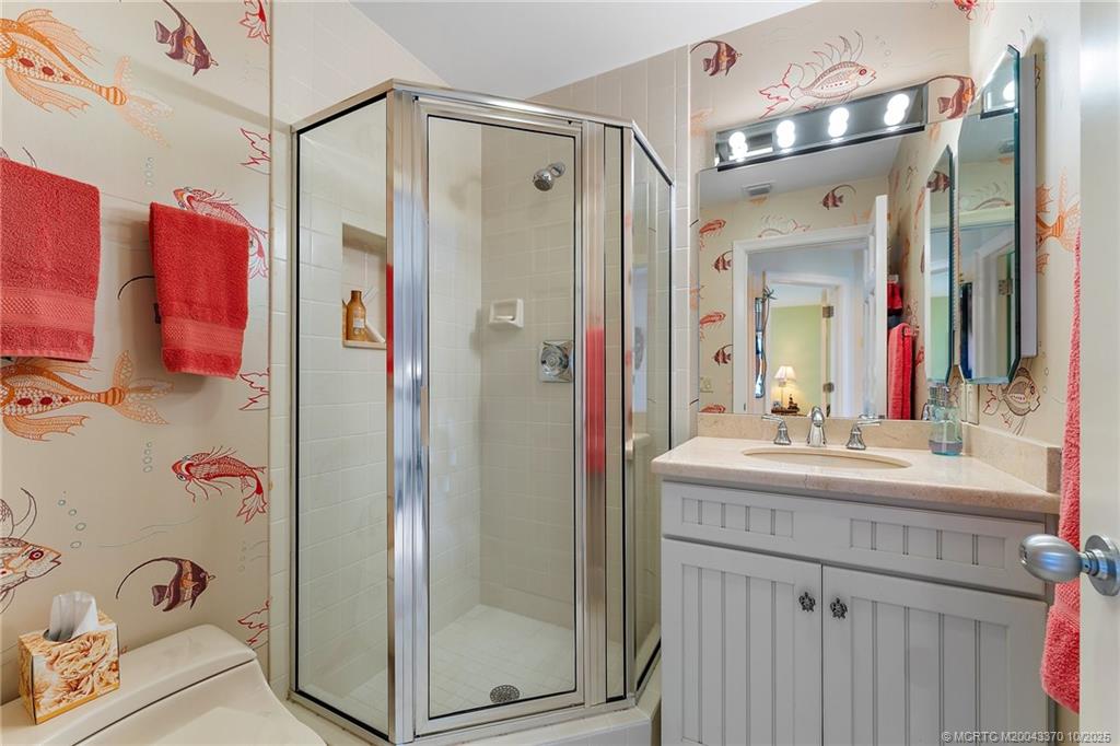 777 Southeast MacArthur Boulevard Stuart, FL 34996 - Photo 33 of 46 a bathroom with a mirror sink and shower