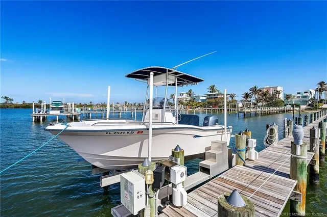 a roof deck with table and chairs a barbeque with wooden floor and city view