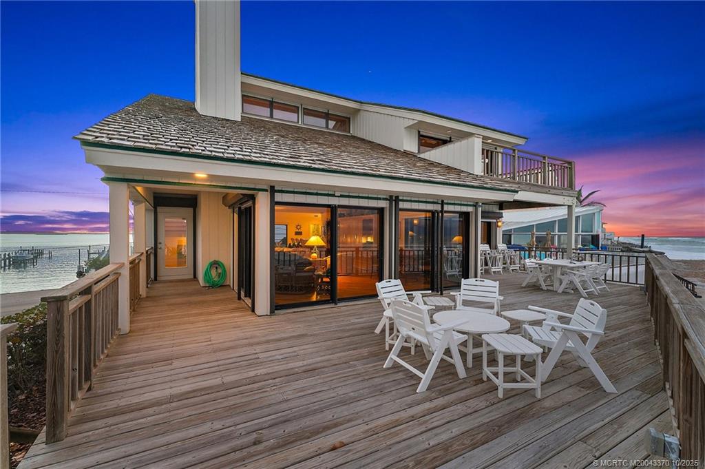 777 Southeast MacArthur Boulevard Stuart, FL 34996 - Photo 42 of 46 a view of a patio with table and chairs with wooden floor and fence