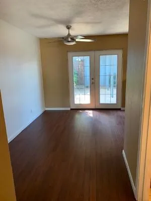 an empty room with wooden floor and windows