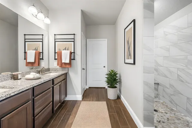 a spacious bathroom with a granite countertop sink a mirror and shower