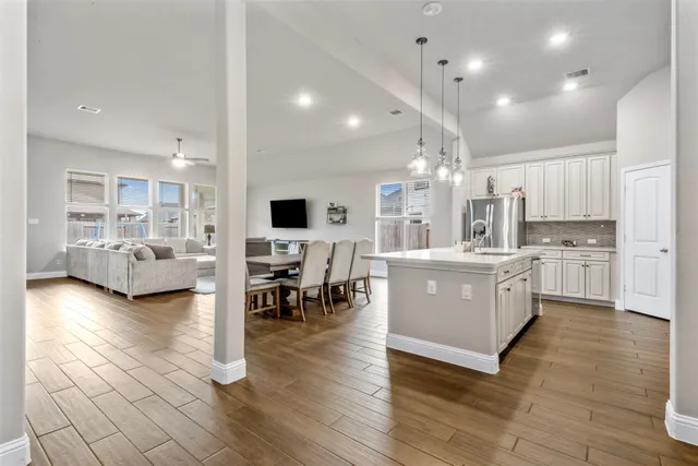 a large kitchen with lots of counter top space a sink appliances and cabinets