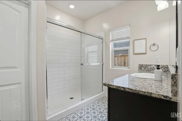 a bathroom with a granite countertop sink and a mirror
