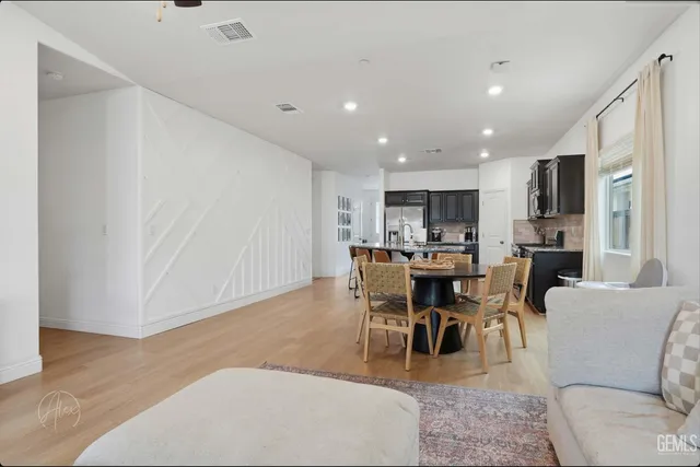 a kitchen with kitchen island wooden floor center island and stainless steel appliances