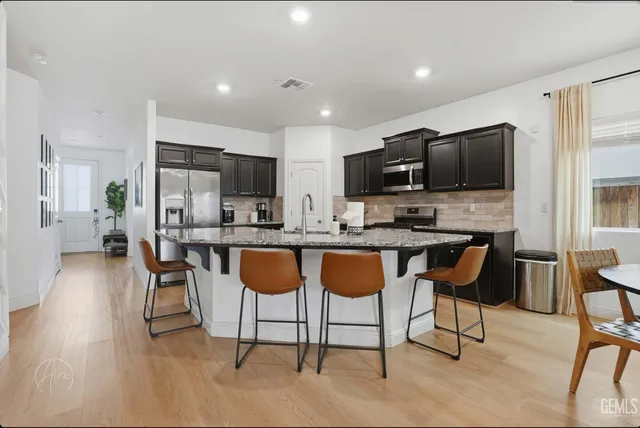 a kitchen with stainless steel appliances granite countertop a sink stove and refrigerator