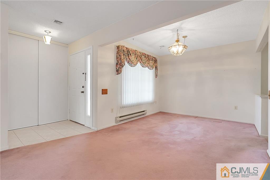 793 Pompton Road, Unit D Monroe Township, NJ 08831 - Photo 7 of 23 an empty room with chandelier fan and windows