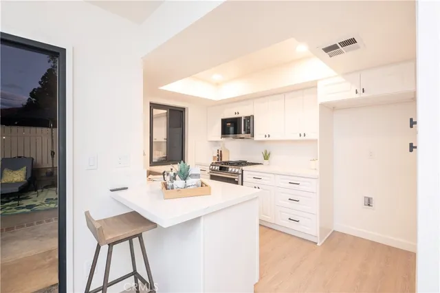 a kitchen with a sink cabinets and wooden floor