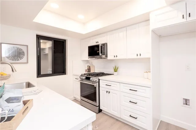 a kitchen with granite countertop a sink and a stove top oven