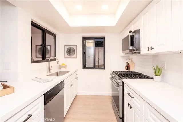 a kitchen with stainless steel appliances a sink stove and cabinets