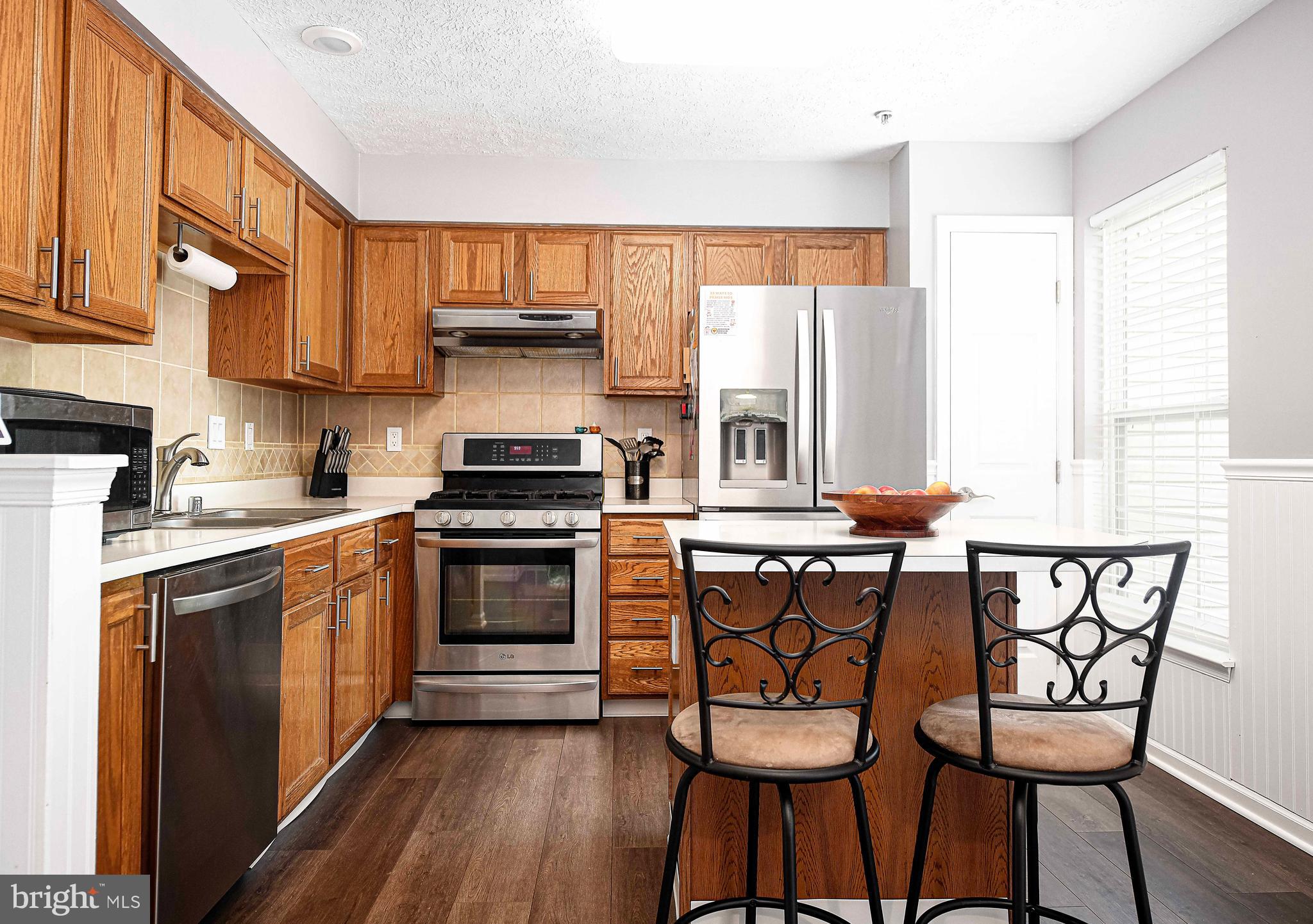 518 MacIntosh Circle Joppa, MD 21085 - Photo 10 of 29 a kitchen with stainless steel appliances a stove a sink cabinets and a dining table