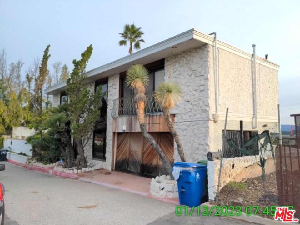 1830 Bel Air Road Los Angeles, CA 90077 - Photo 3 of 12 a front view of a house with garden