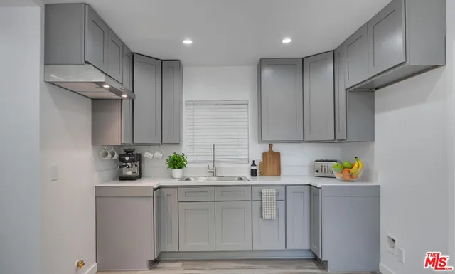a kitchen with white cabinets and sink