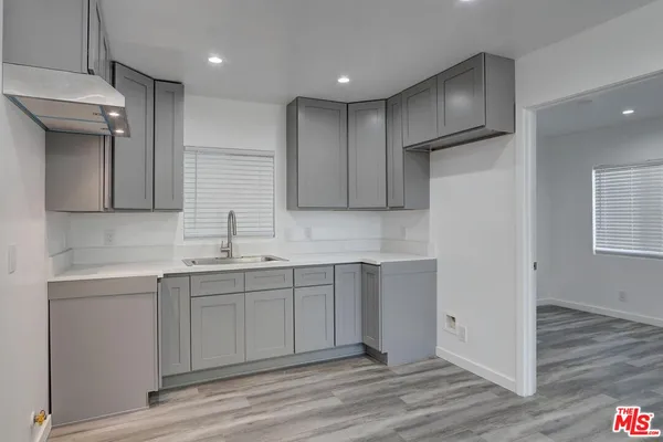 a kitchen with a sink cabinets and wooden floor