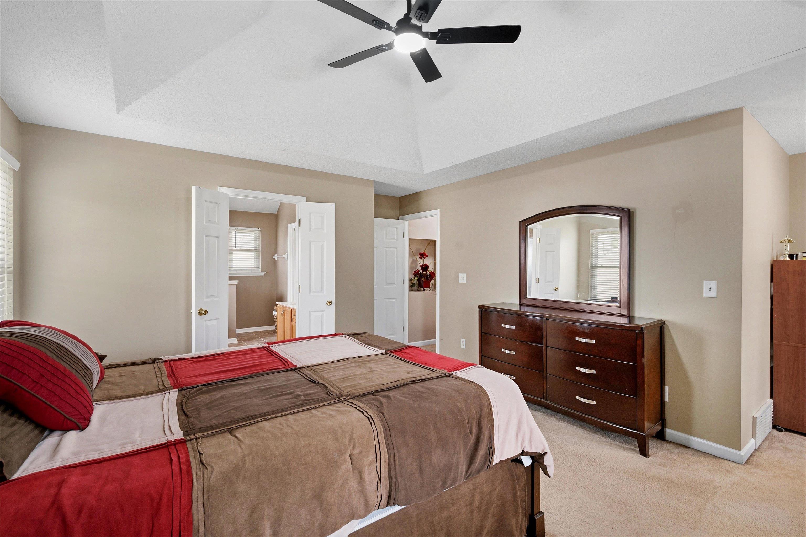 7779 Windy Willow Road Memphis, TN 38125 - Photo 14 of 30 Vaulted ceiling bedroom featuring a ceiling fan with integrated lighting, neutral wall tones, and carpeted flooring