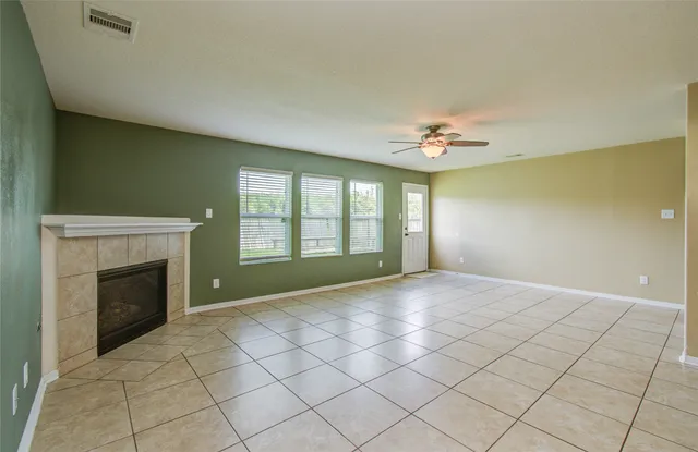 a view of an empty room with a fireplace and a window
