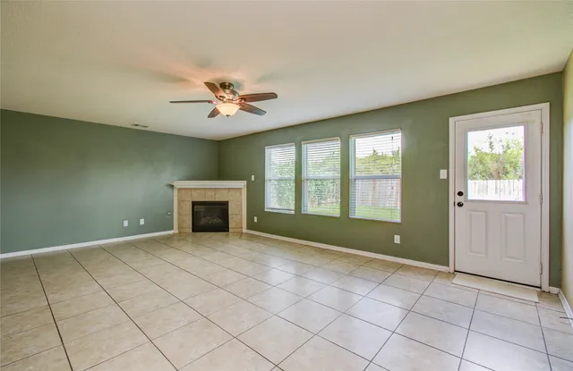 a view of an empty room with a fireplace and a window