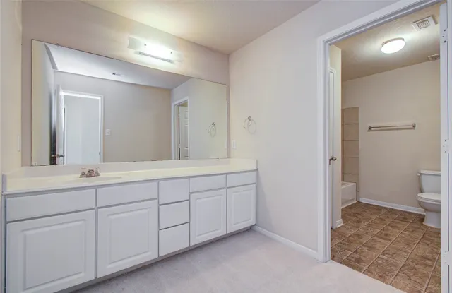 a spacious bathroom with a sink and a mirror