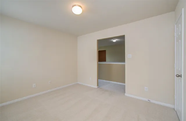 an empty room with closet and windows