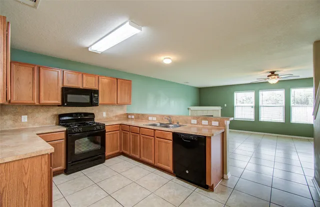 a kitchen with a stove sink and cabinets