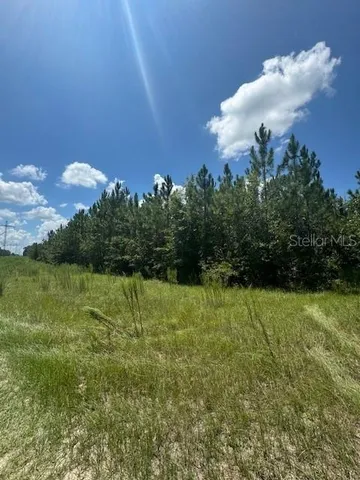 a street sign that is sitting in the grass next to a building