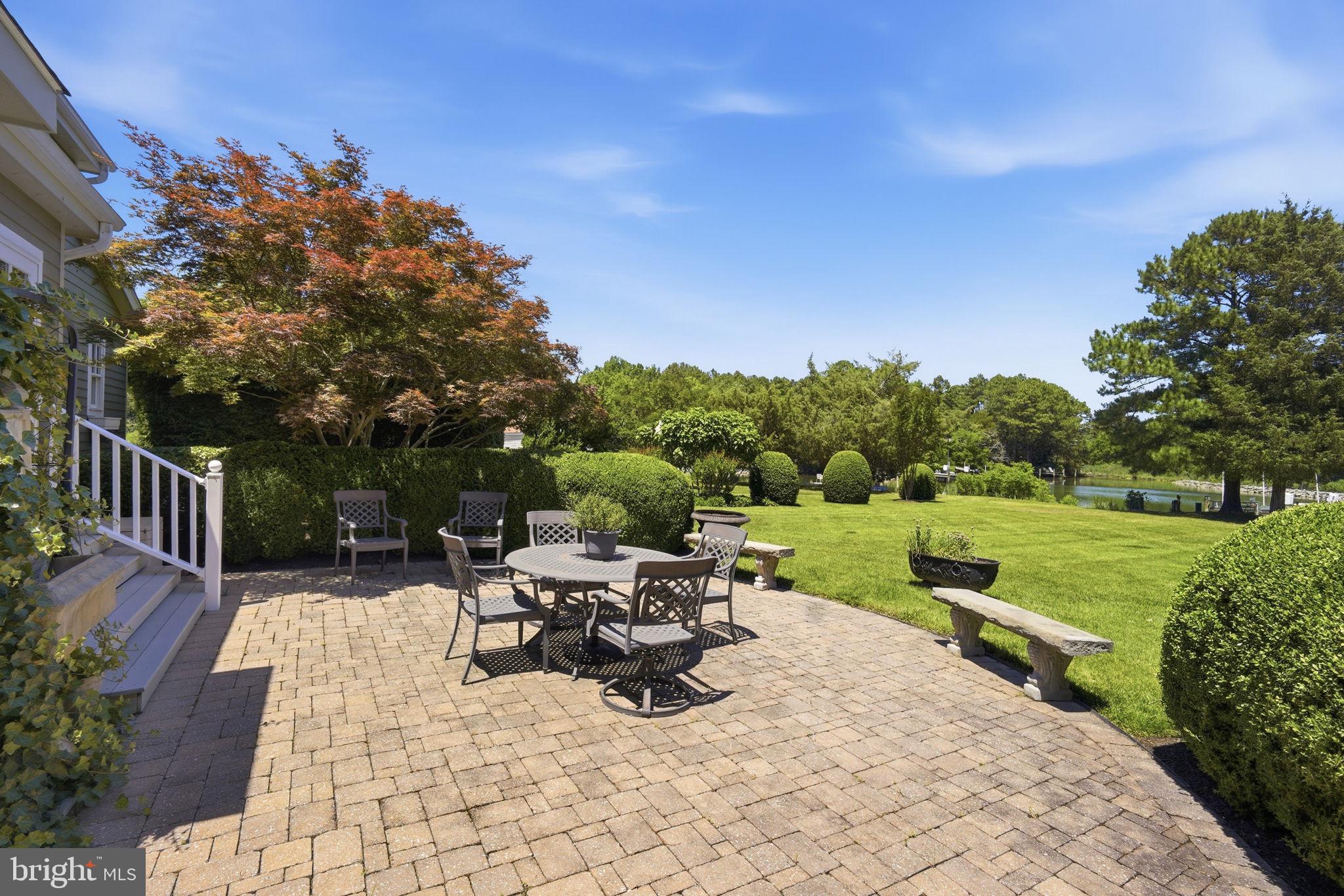 26226 Langs Landing Road Oxford, MD 21654 - Photo 37 of 48 a view of a patio with a table chairs and a garden