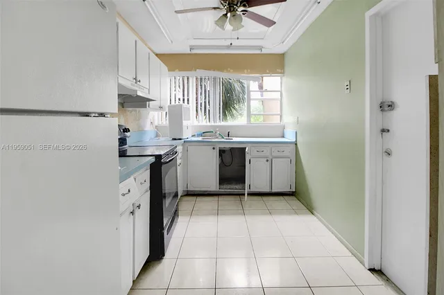 a kitchen with a sink a stove cabinets and a window