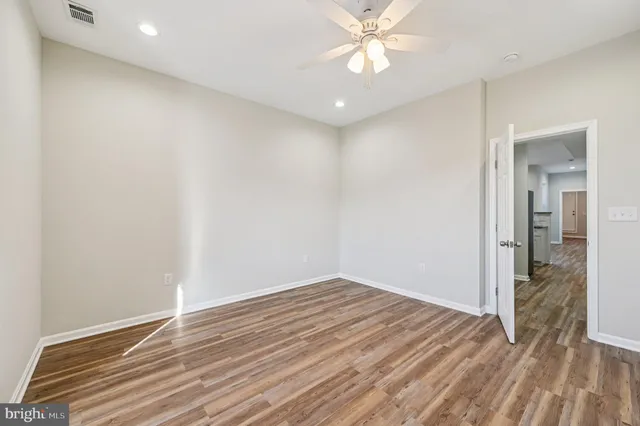 a view of a room with wooden floor and a ceiling fan