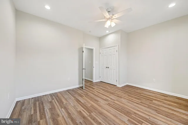 a view of a room with wooden floor and a ceiling fan