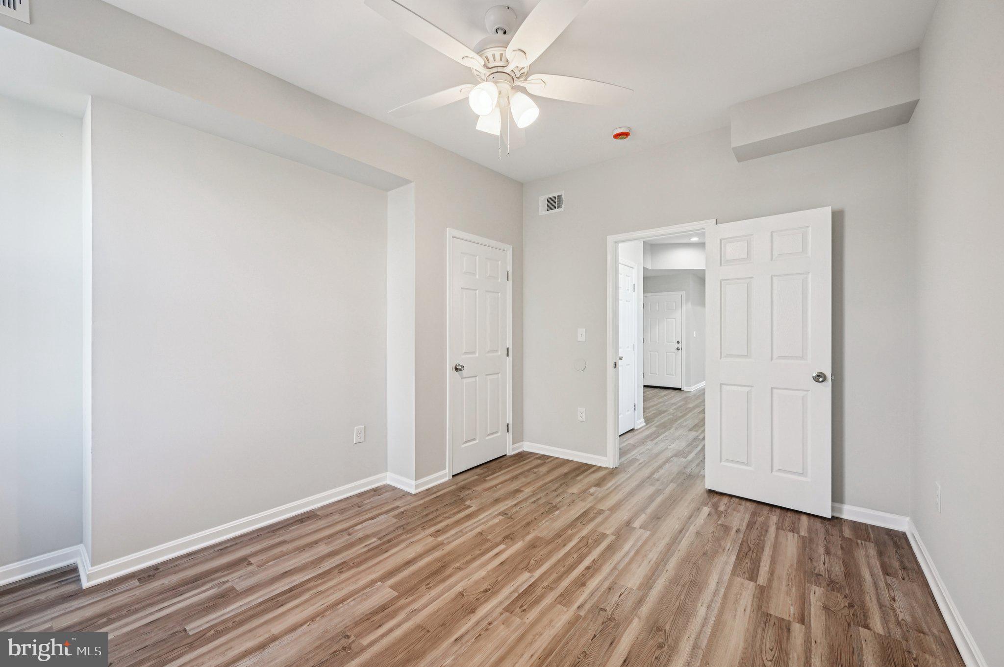 750 Reservoir Street, Unit C Baltimore, MD 21217 - Photo 21 of 25 a view of a room with wooden floor and a ceiling fan